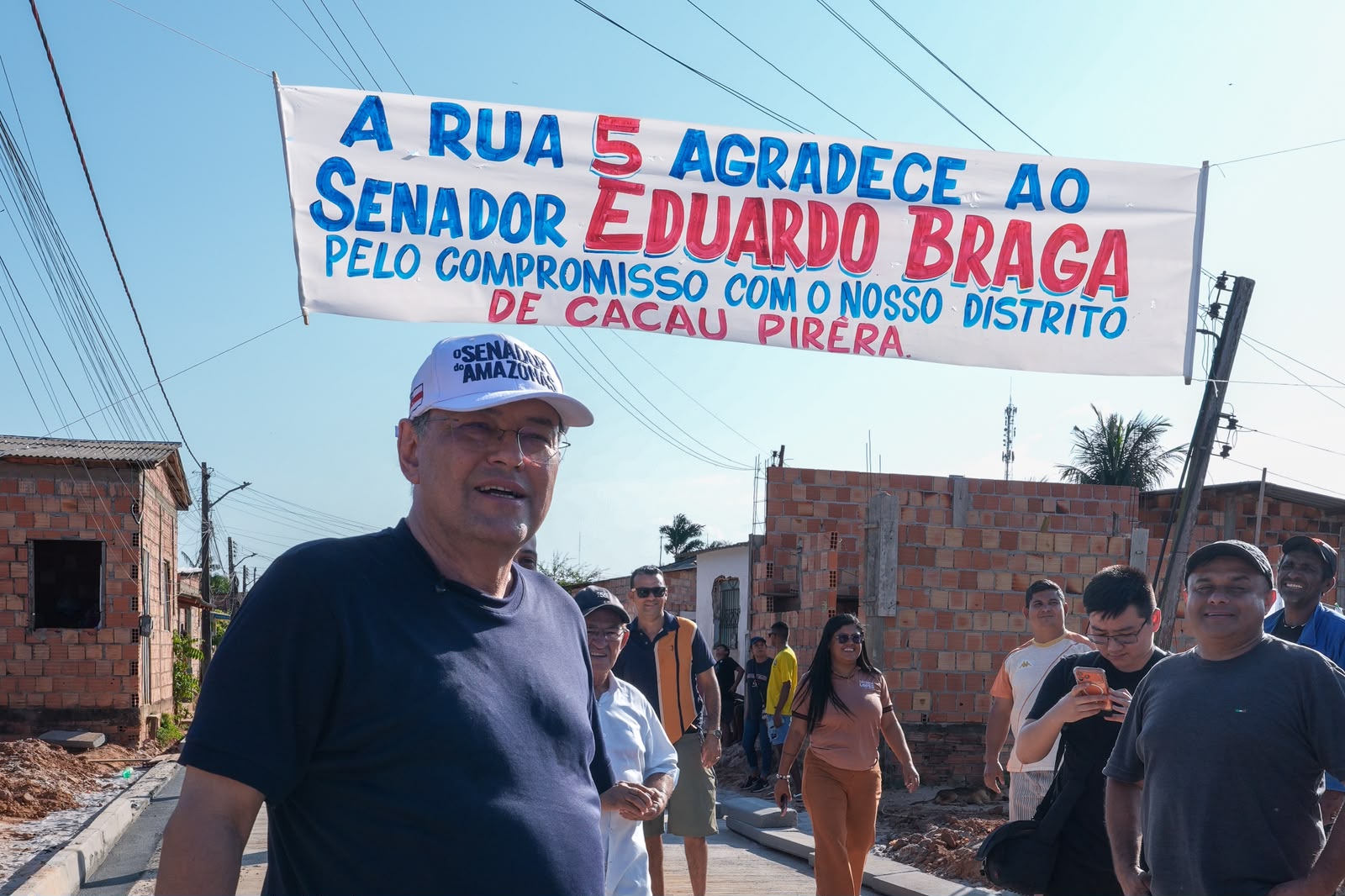 No momento, você está visualizando Morador que duvidava da pavimentação recebe Eduardo Braga com faixa de agradecimento no Cacau Pirêra